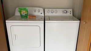 Une buanderie équipée de deux machines à laver à chargement frontal blanches et d’un sèche-linge.