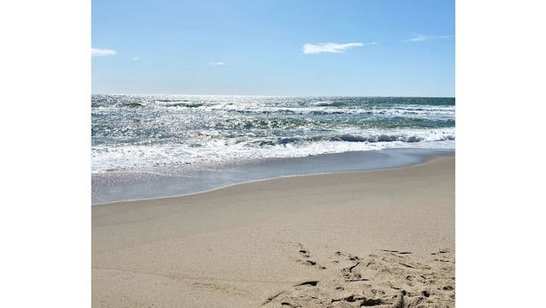 A beach with clear skies and waves.
