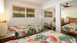 A bedroom with two beds, a ceiling fan, a mirror, and a window with blinds. - Ocean View 2 Bedroom Kahalu'u Reef KR301 (Kailua Kona)