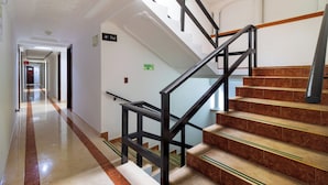 Pasillo de hotel con una escalera que sube hasta el cuarto piso.