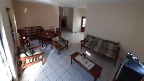 Un salón amplio con sofá, sillones, una mesa de centro y un comedor con mesa y sillas.