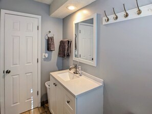 A bathroom with a white vanity, a mirror, and a towel rack. - Cozy, clean & spacious townhouse - Unit 1 (Overland Park)