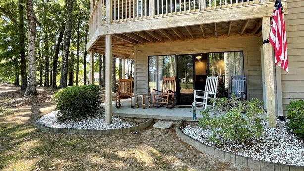 Une cabane en bois dotée d’un balcon, d’un espace salon extérieur et d’un drapeau américain.