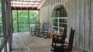 A wooden deck with a covered area, large windows, and string lights. - Views of Elk River with wrap-around screened porch for family time (Athens)
