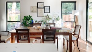 A dining area with a wooden table, four chairs, and a ceiling light fixture. - Beautifully renovated hot-tub, large fenced backyard, pet friendly (Kirkland)