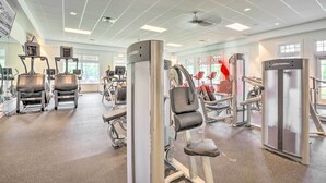 Ett gym med konditionsmaskiner, styrketräningsstationer och speglar.