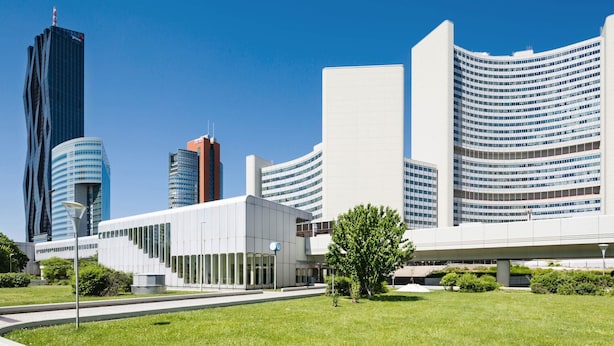 Ein modernes Gebäude mit einer geschwungenen Fassade, einem flachen Dach und einem großen Glas Eingang.