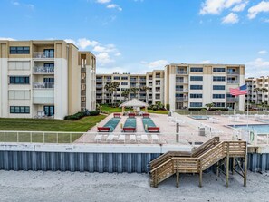 A hotel with multiple floors, outdoor pool, and a gazebo. - Castle Reef 533 stunning direct ocean front view! (New Smyrna Beach)