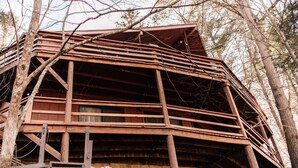 A rustic wooden cabin with a multi-level deck, surrounded by trees. - Multi-Family Cabin @ Shenandoah Bryce Resort (Basye)