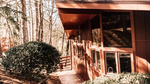 A wooden cabin with a covered porch, large windows, and a pathway leading to the entrance. - Multi-Family Cabin @ Shenandoah Bryce Resort (Basye)