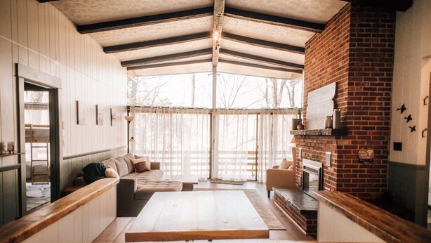 A cozy interior with a wooden bench, a sofa, and a fireplace. - Multi-Family Cabin @ Shenandoah Bryce Resort (Basye)
