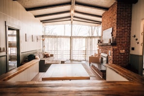 A cozy interior with a wooden bench, a sofa, and a fireplace.