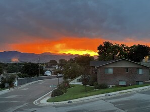 Une rue résidentielle bordée de maisons, un ciel dégagé et un coucher de soleil.
