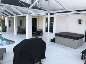 Une terrasse extérieure dotée d’un espace salon couvert, d’un jacuzzi et d’une piscine.
