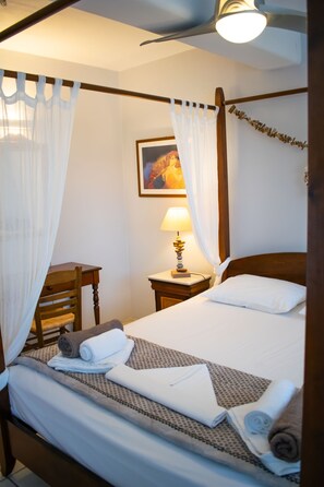 Restful retreat with a classic four-poster bed and comfortable seating area.