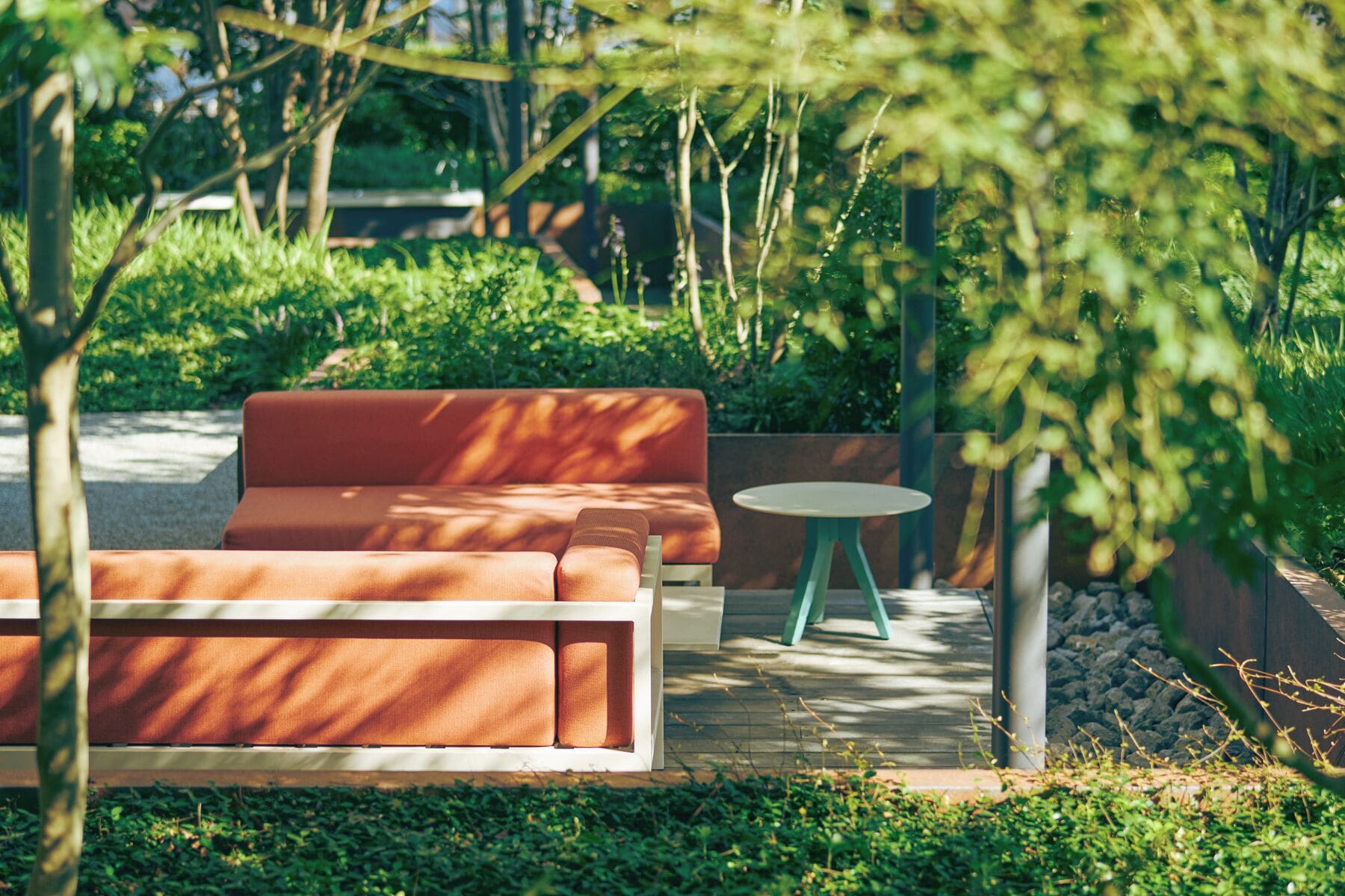 A wooden deck with a sofa and a small round table.