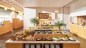 Ein modernes Frühstücksbuffet mit verschiedenen Speisen und einem klaren, minimalistischen Interieur.