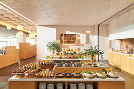 A modern breakfast buffet with various food items and a clean, minimalist interior design.