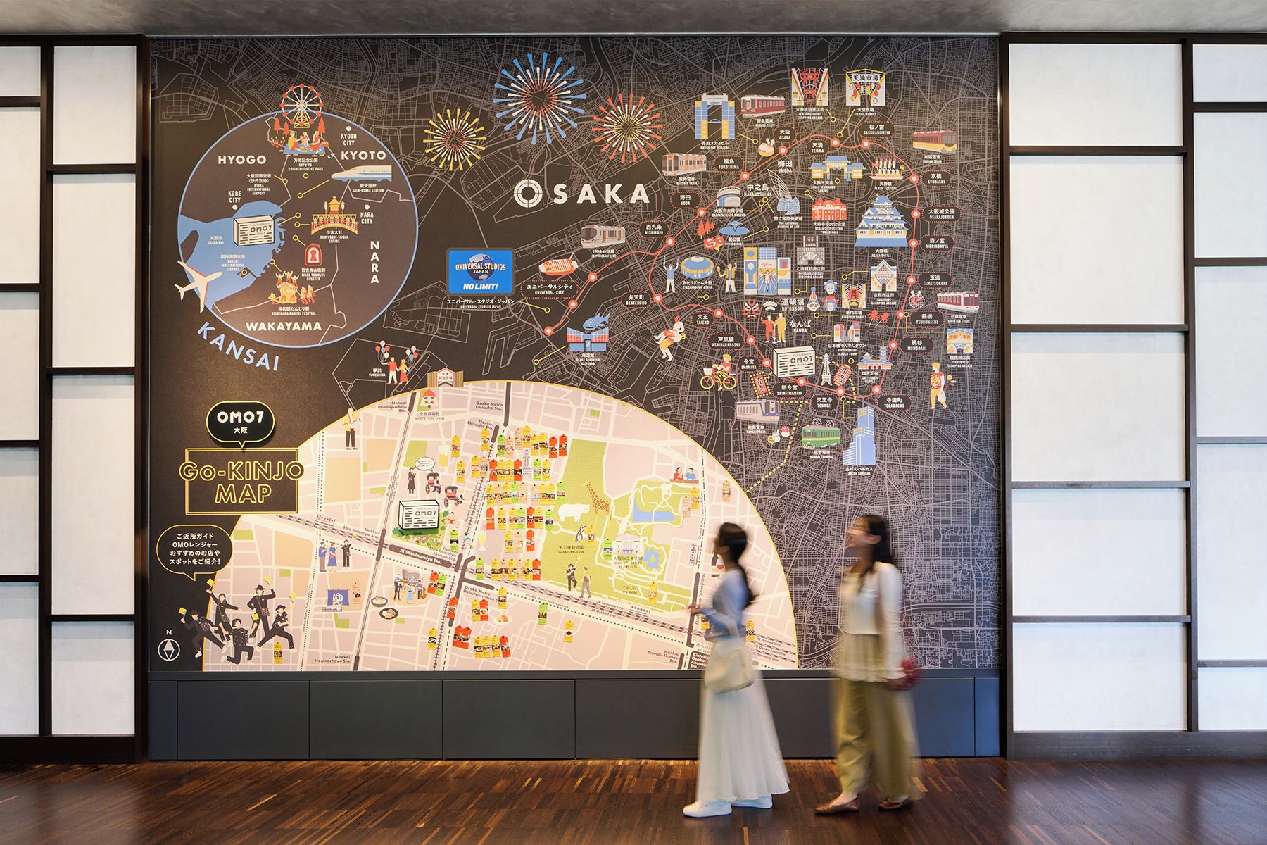 Un gran mapa de pared de Osaka con zonas resaltadas e iconos que señalan lugares de interés y monumentos.