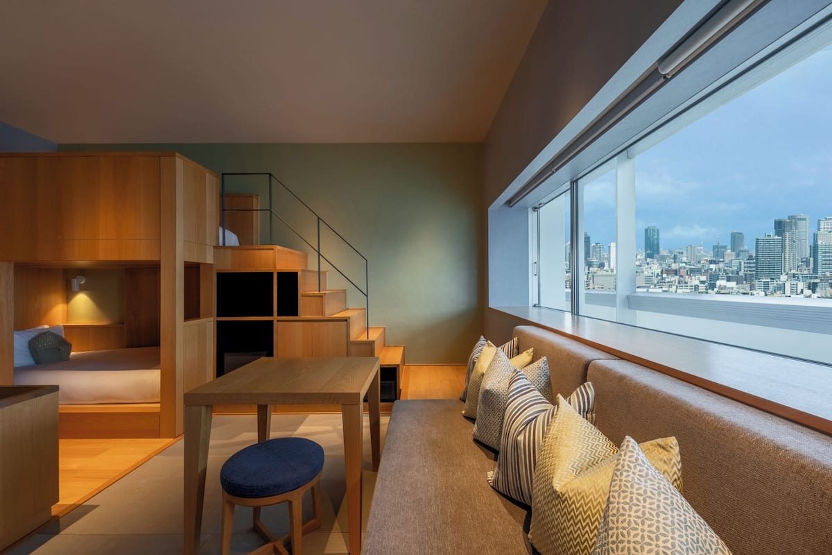 Ein modernes Interieur mit Stadtblick, einer Treppe, einem Sofa und einem Essbereich.