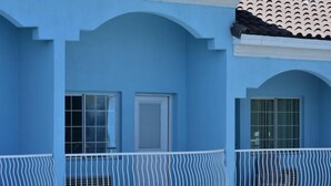 Ein blaues Gebäude mit zwei Fenstern und einem weißen Balkon.