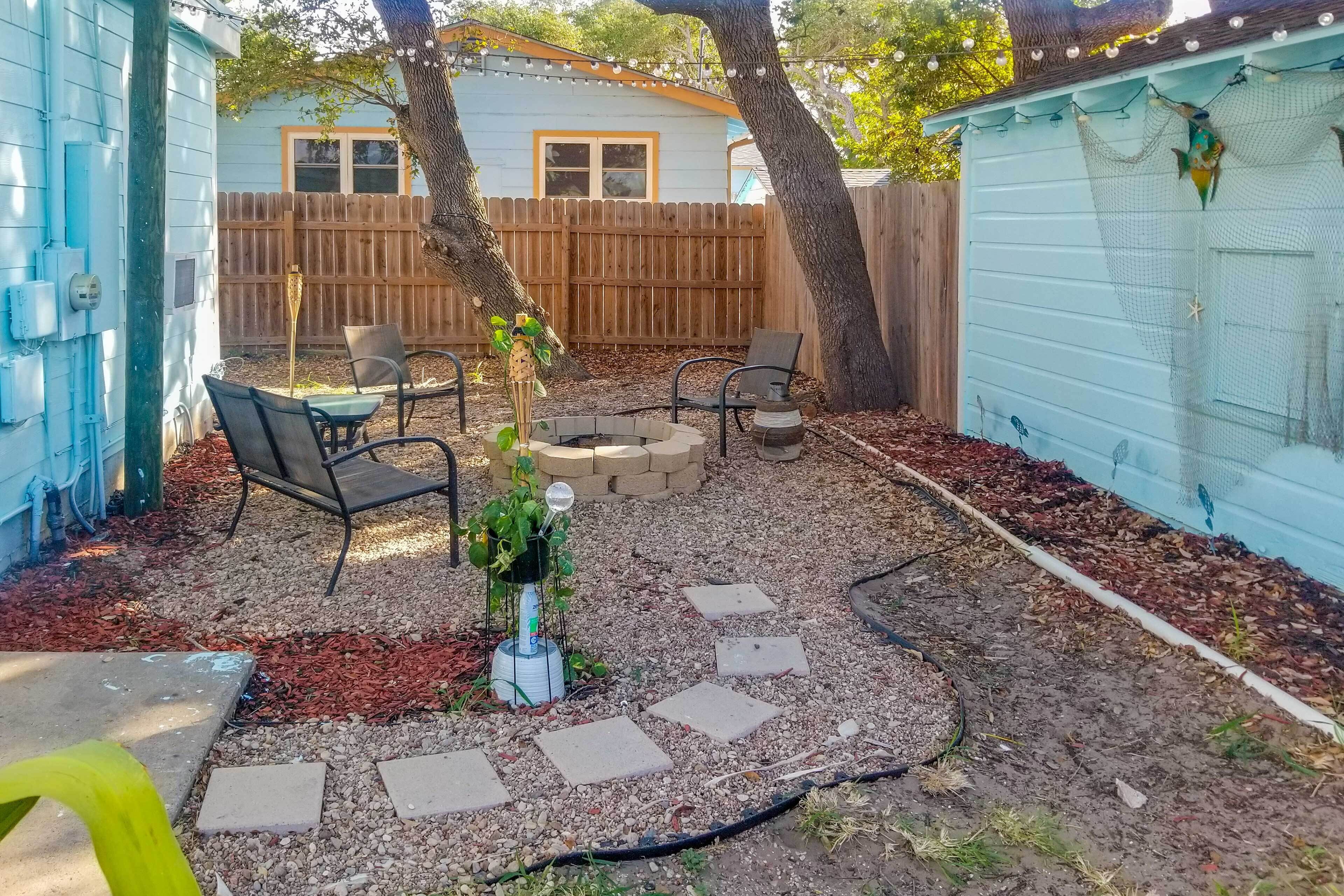 A backyard with a patio area, outdoor seating, and a small garden.