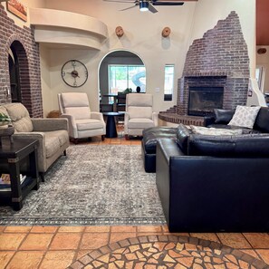 Ein Wohnzimmer mit Kamin, zwei Sofas, einem Couchtisch und einem Teppich.