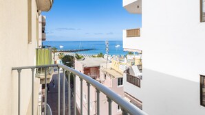 Ein Balkon mit Meerblick, eine Treppe und ein Gebäude mit Balkon.