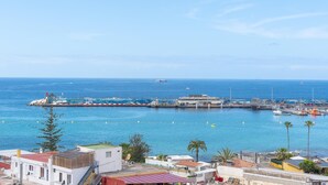 A coastal town with a marina, buildings, and a clear blue sky.