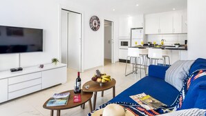 A modern apartment with a living room, dining area, and kitchen.