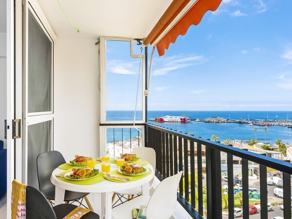 A balcony with a table set for breakfast, overlooking a marina and the sea. - 76. Los Cristianos first sea line, Wi Fi (Los Cristianos)
