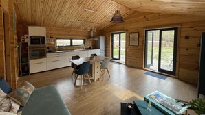Ein geräumiges Holzhaus-Interieur mit Küche, Essbereich und einem gemütlichen Wohnraum.