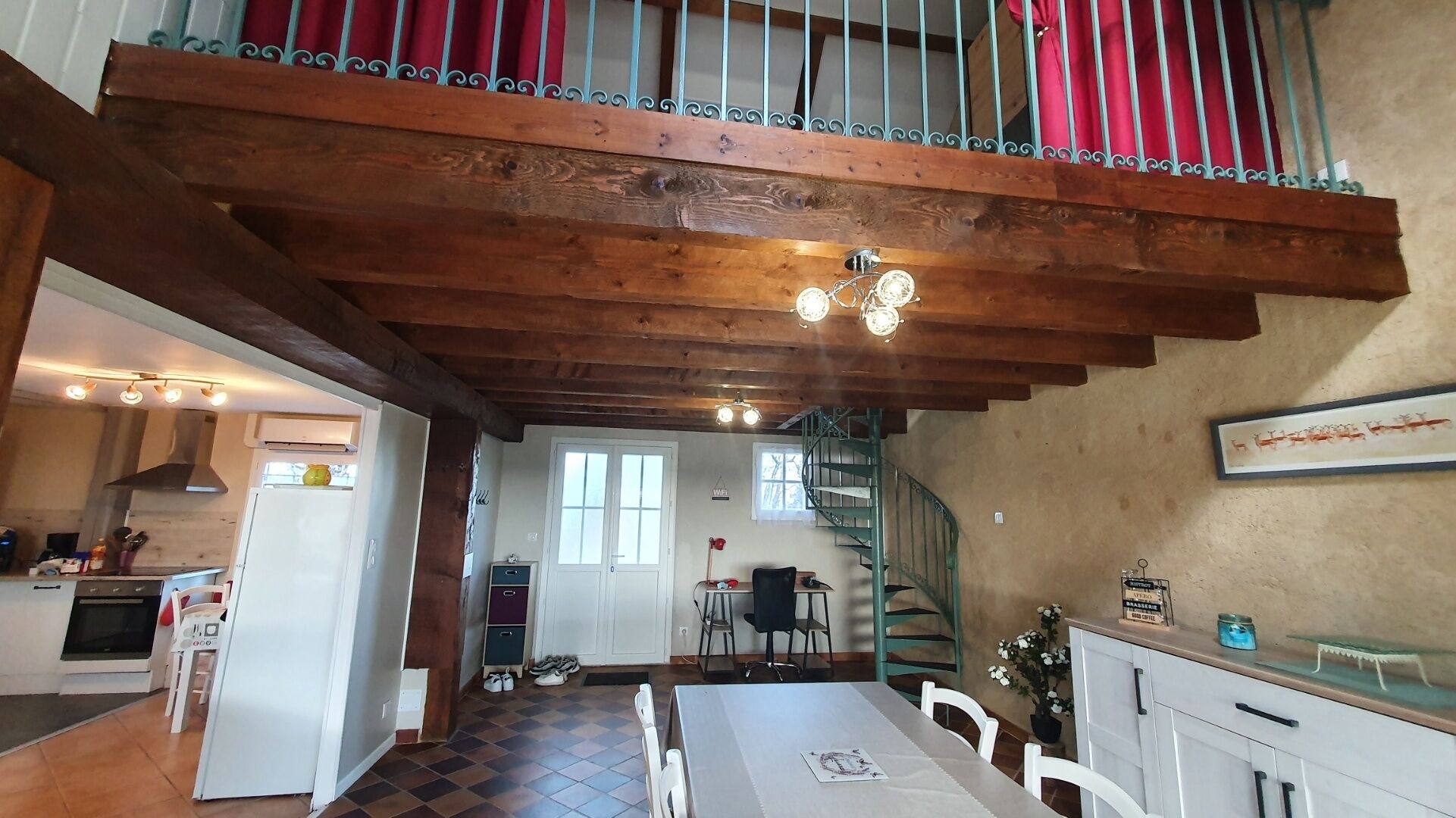 A spacious kitchen with a dining area, a staircase, and a view of the outside.