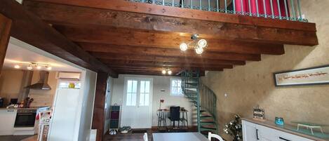 A spacious kitchen with a dining area, a staircase, and a view of the outside.