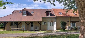 A two-story building with a sloped roof, multiple windows, and a small porch area. - Le Bellevue, quiet gite with panoramic view 10 minutes from Sarlat (Vezac)