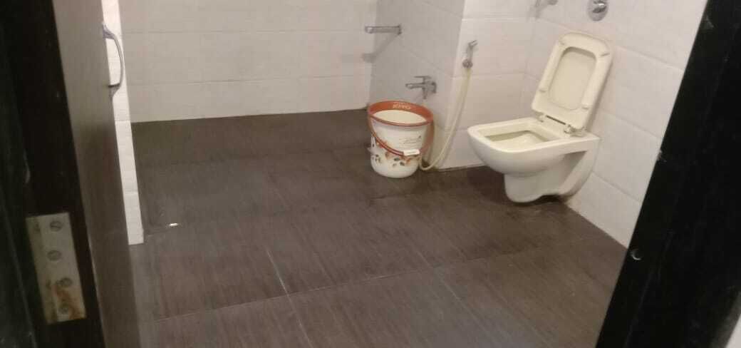 A small bathroom with a toilet and a bucket.