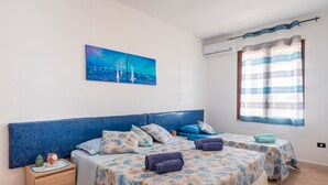 A bedroom with two beds, a nightstand, a painting, and a window with curtains. - Villa "Casa Vacanza Errante" with Sea View, Pool & Wi-Fi (menfi)