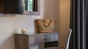 A small, modern room with a grey desk, a chair, a decorative handbag, and a television mounted on the wall. - Casa De' Fiori Kefalonia★Family Retreat (Σκάλα)