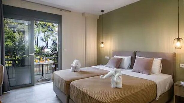 A hotel room with two beds, a balcony, and a table outside. - Casa De' Fiori Kefalonia★Family Retreat (Σκάλα)