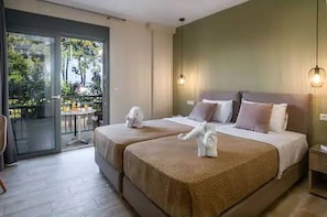 A hotel room with two beds, a balcony, and a table outside.