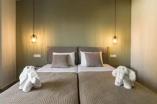 A hotel room with a double bed, two bedside tables, and two wall-mounted lamps.