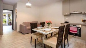 A modern kitchen with a dining area, a sofa, and a view of the outdoors. - Casa De' Fiori Kefalonia★Family Retreat (Σκάλα)