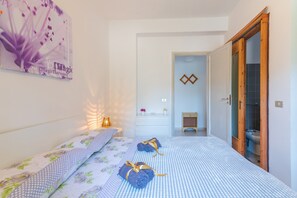 A bedroom with a bed, bedside table, and a nightstand.