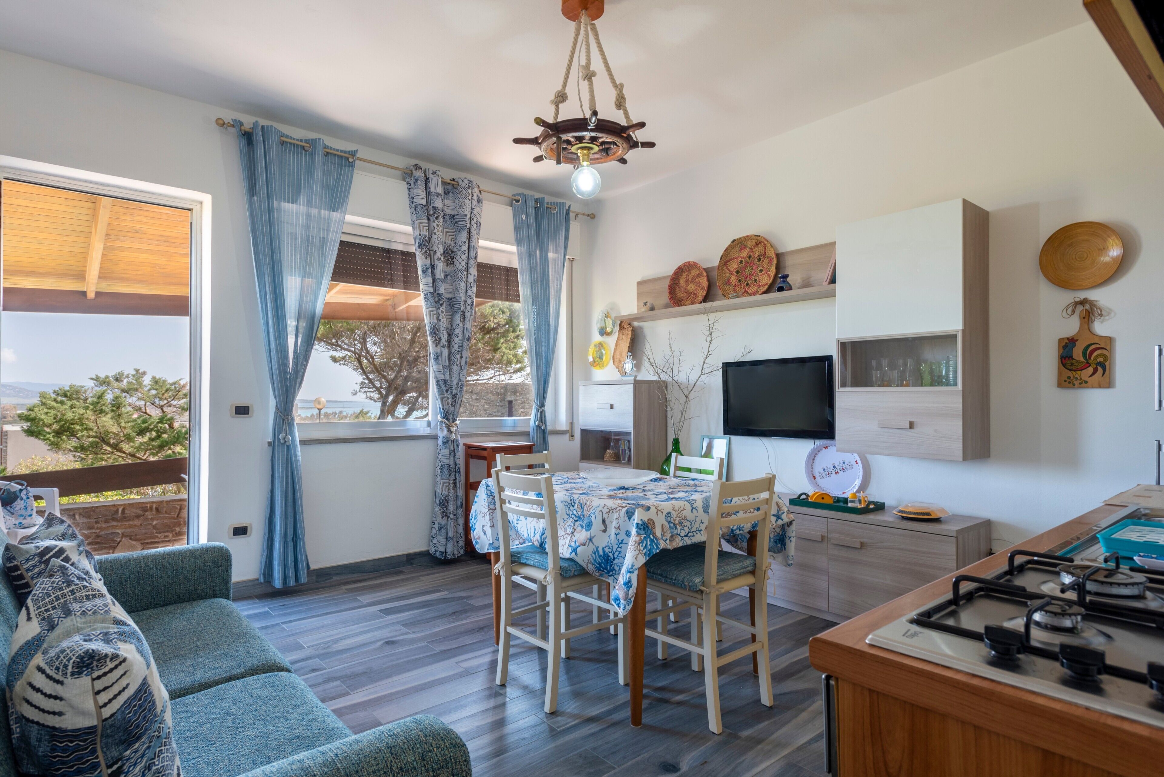 A cozy living room with a sofa, a dining table, and a kitchen area with a stove.
