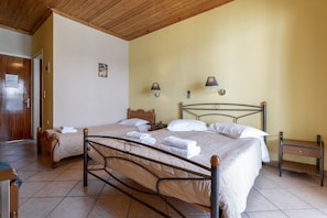 A double bed with a wooden headboard, two bedside tables, and a small nightstand.