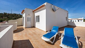 A rooftop terrace with two sun loungers, a white building, and a clear blue sky. - Holiday Home Villas Brites nº5 with Open Terrace, Shared Pool & Wi-Fi (Burgau)