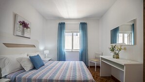 A bedroom with a bed, bedside table, chair, desk, and a mirror. - Holiday Home Casa Fernandes with Shared Pool, Open Terrace & Wi-Fi (Burgau)