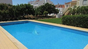 A rectangular swimming pool with a tiled edge, surrounded by a paved walkway. - Holiday Home Casa Fernandes with Shared Pool, Open Terrace & Wi-Fi (Burgau)