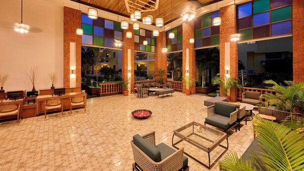 Un espacio interior amplio con diversas opciones de asientos, incluyendo sofás y sillones, y una chimenea central.