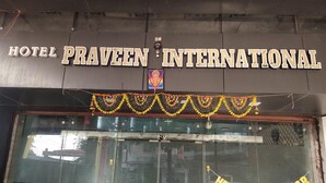 Hotel Praveen Internationals fasad med en banderoll med texten ”Gott nytt år”.
